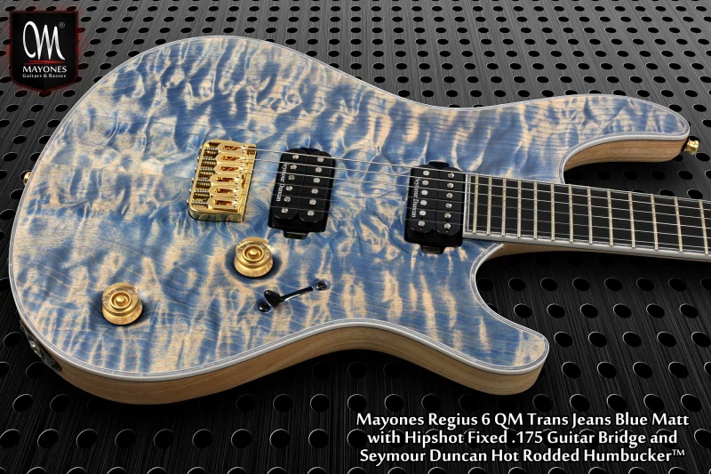 A close-up of a Mayones Regius 6 guitar in Trans Jeans Blue Matt finish, featuring a Hipshot Fixed bridge and Seymour Duncan Hot Rodded humbucker, highlighting its stunning design and craftsmanship.