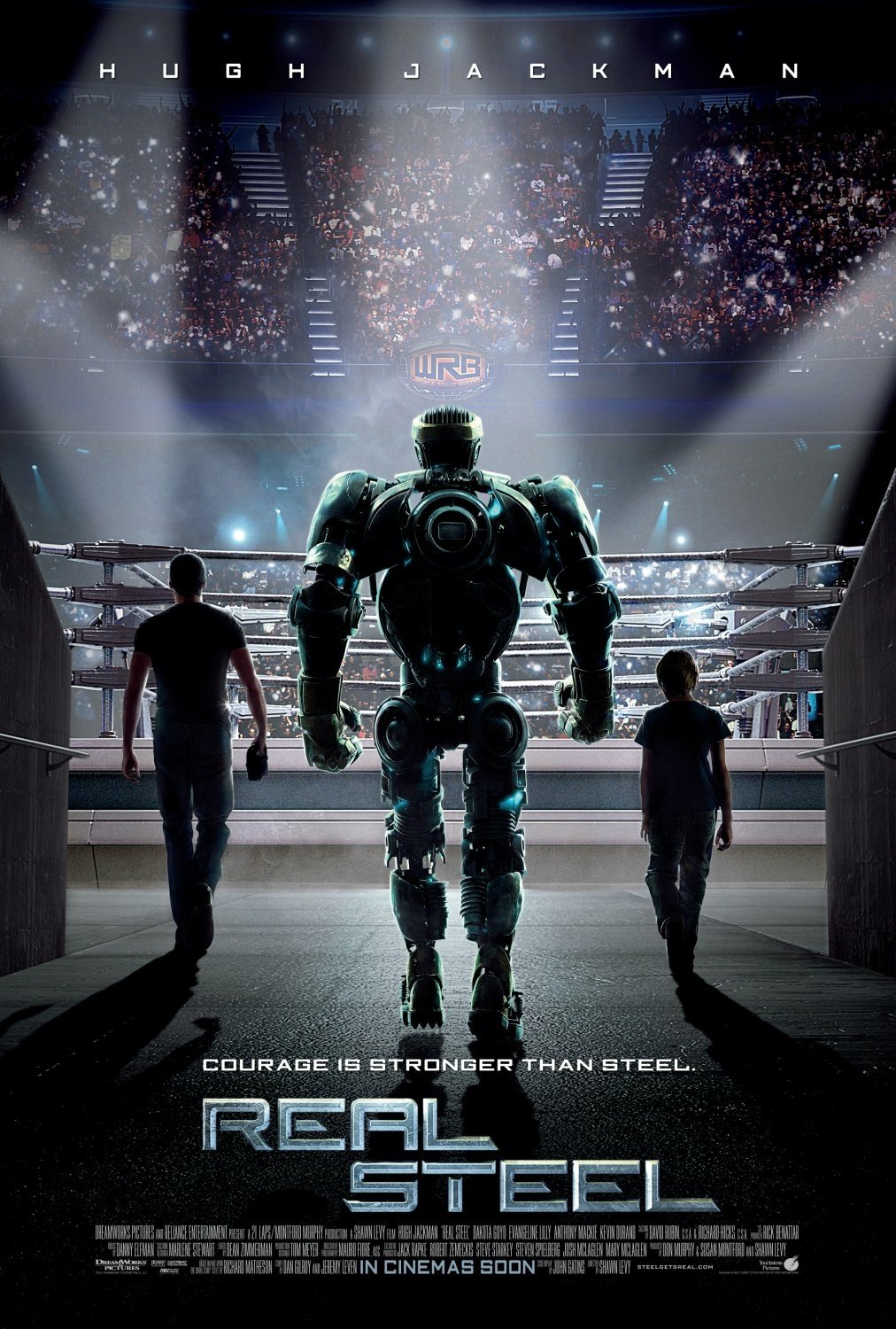 Movie poster for Real Steel: a towering boxing robot walks toward a lit arena ring flanked by two human figures, crowd and spotlights filling the stadium behind them.