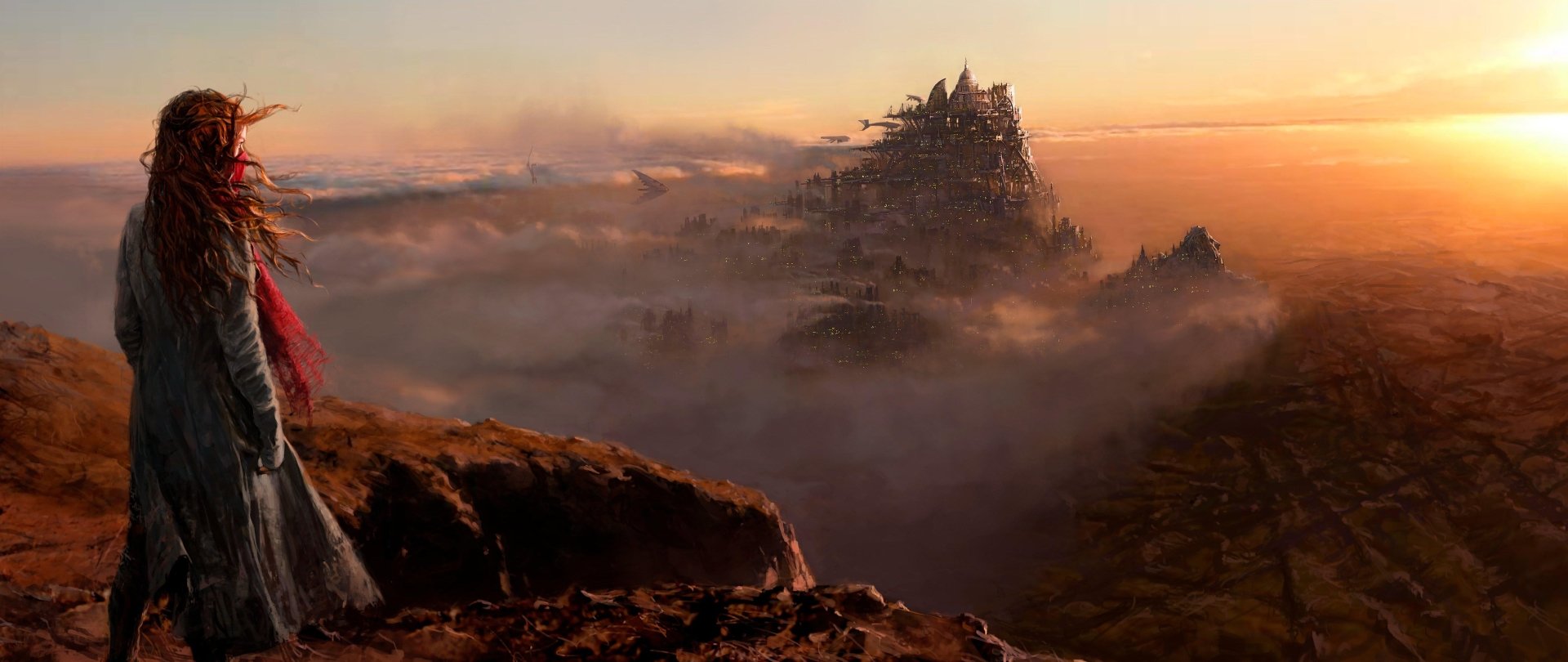 Hera Hilmar's character in the movie Mortal Engines stands on a cliff overlooking a vast, mist-covered city moving through a barren landscape at sunset.