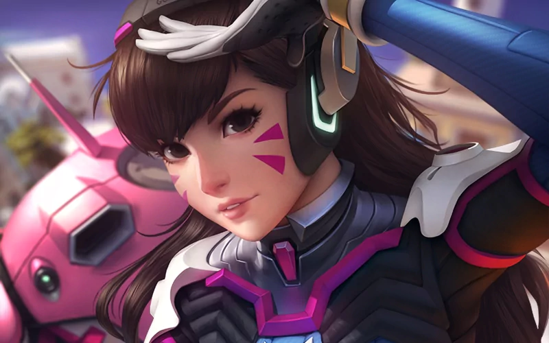 Close-up of D.Va from the video game Overwatch, showcasing her headset, signature face paint, and futuristic armor with her mech partially visible in the background.
