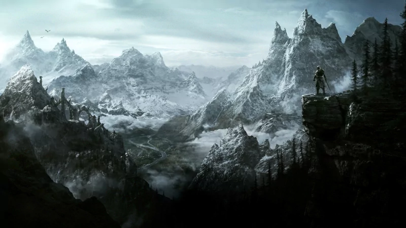 A breathtaking landscape from The Elder Scrolls V: Skyrim, showcasing a lone figure overlooking majestic snow-capped mountains and a misty valley beneath a dramatic sky.