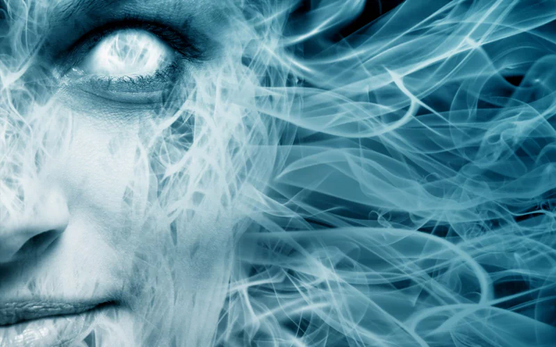 A close-up of a face with glowing eyes, surrounded by swirling elemental mist, evokes a sense of fantasy and mystery in a captivating, ethereal atmosphere.