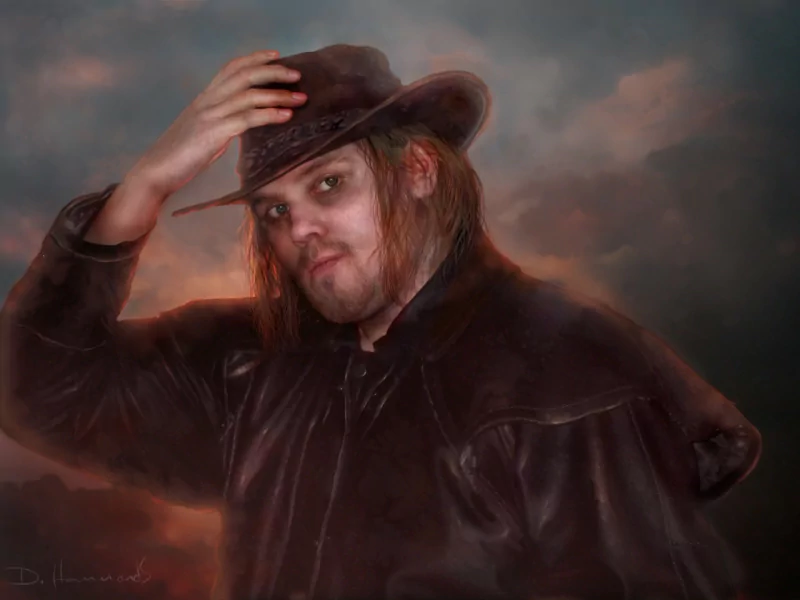 Artistic portrait of a cowboy with long hair and a leather coat tipping his hat against a moody, clouded sky.