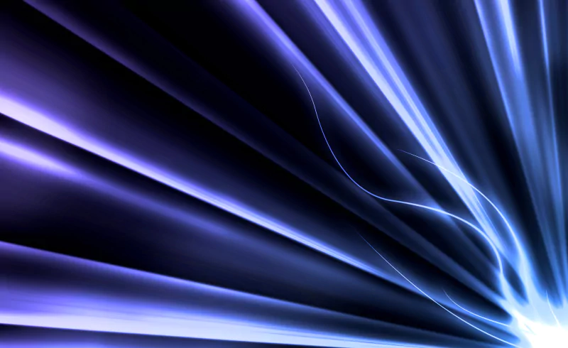 An abstract digital art piece featuring dynamic streaks of blue and purple light radiating outward, creating a sense of motion and depth against a dark background.