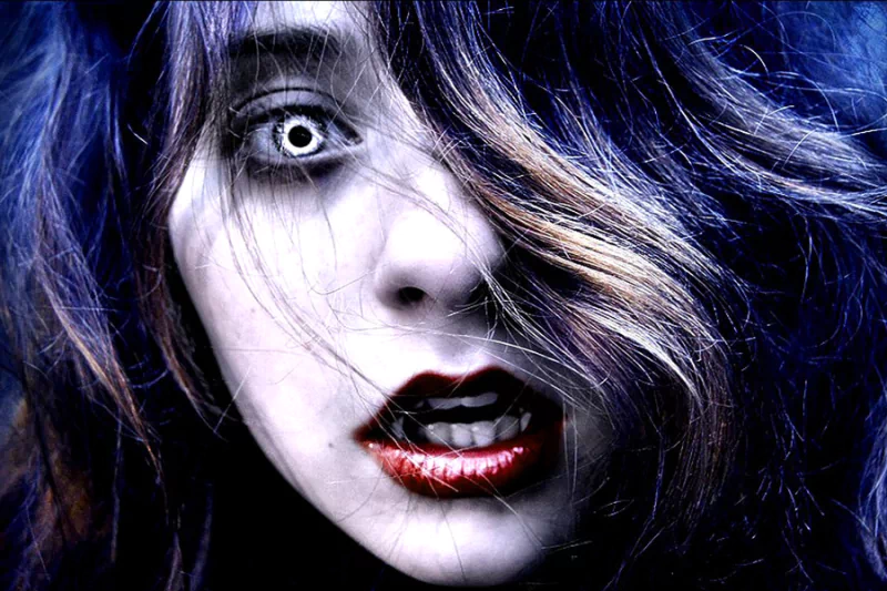 A close-up of a vampire-like figure with striking white eyes and bold red lips, surrounded by dark hair, embodying a captivating blend of fantasy and the supernatural.