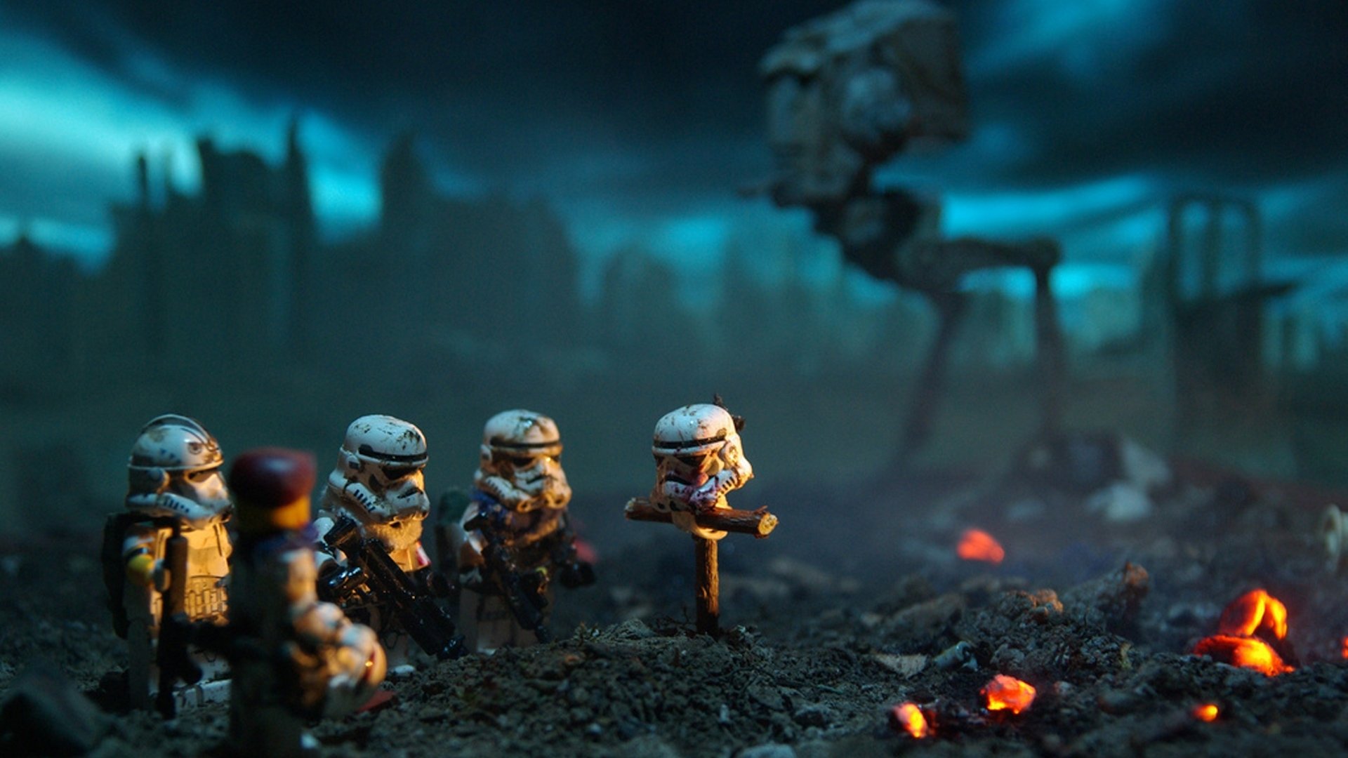 Photography and manipulation depict toy soldiers gathered around a makeshift memorial in a smoky, war-torn battlefield with a looming robotic walker in the background.