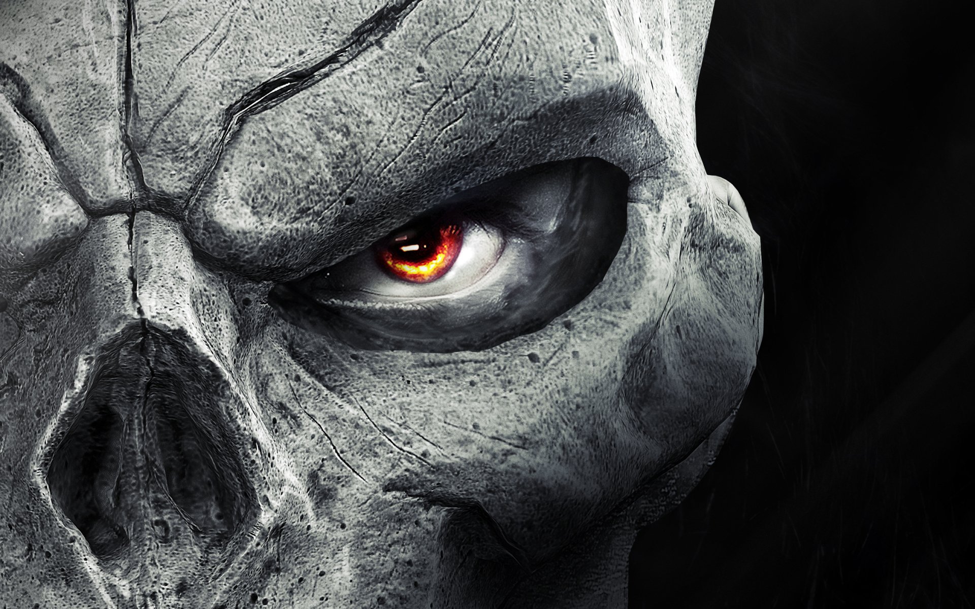 Close-up of a cracked, stone-like skull with a glowing orange eye, representing the video game Darksiders.