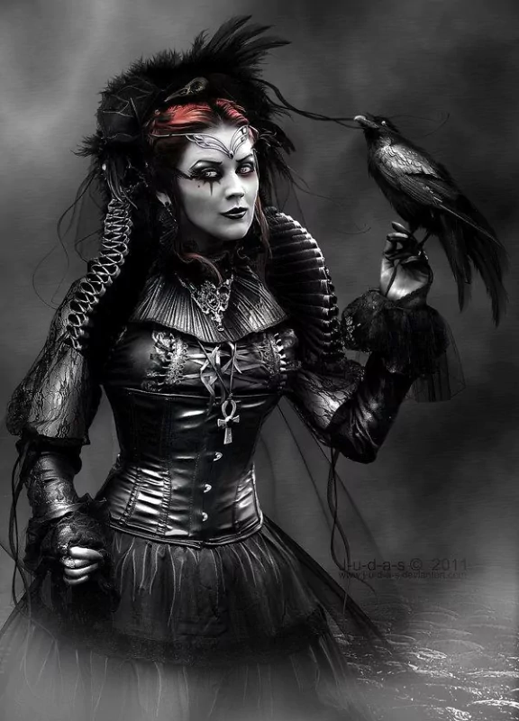 A dark witch in a striking black outfit, adorned with feathers and intricate details, holds a raven. Her dramatic makeup adds to the mystical and eerie atmosphere of the image.