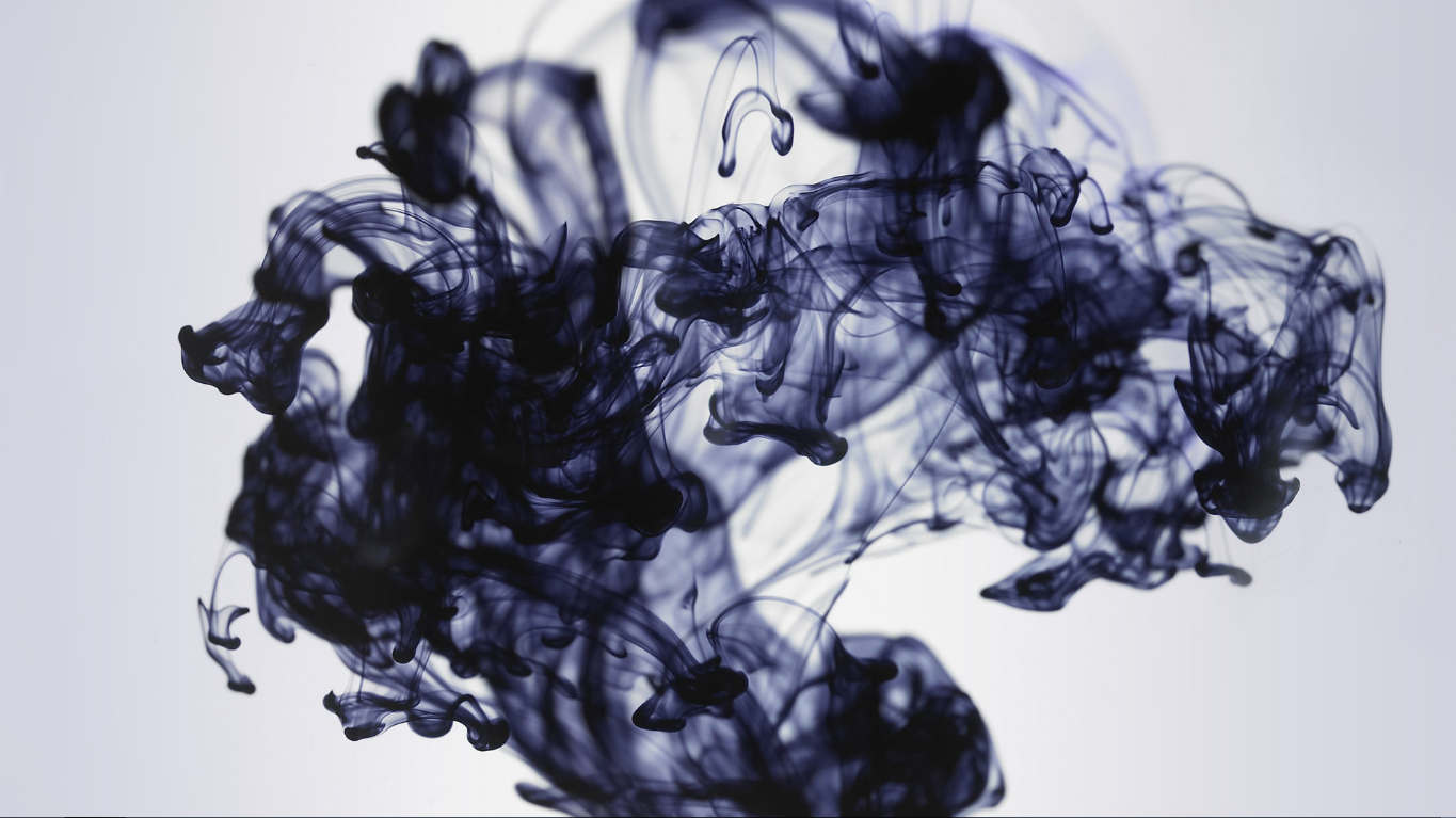 Abstract diffusion of dark indigo ink swirling through pale water, forming smoky, cloudlike tendrils and fluid, marbled shapes.