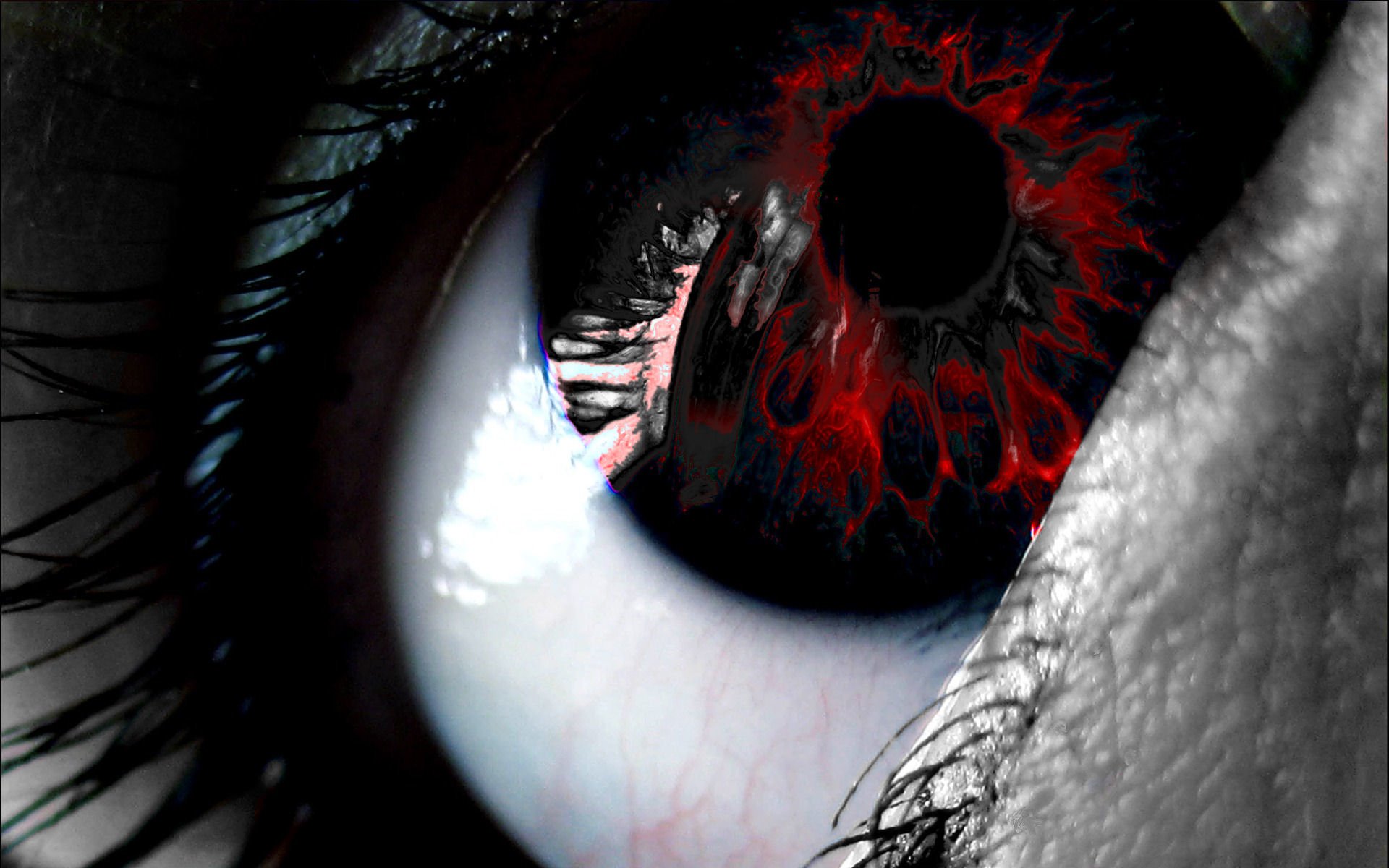 A close-up of a dark eye with vivid red patterns around the pupil, showcasing an intense and striking visual contrast against the white sclera.