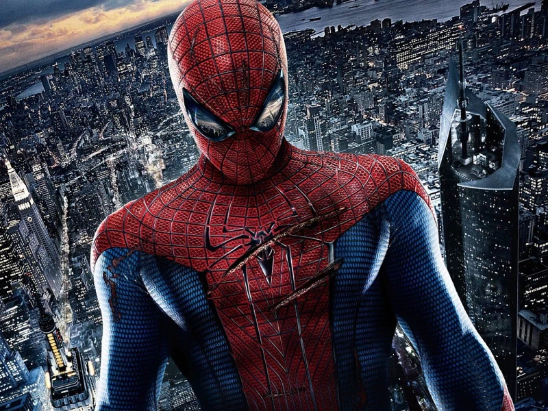 Spider-Man in red-and-blue suit stands over a nighttime city skyline — promotional image from the movie The Amazing Spider-Man.