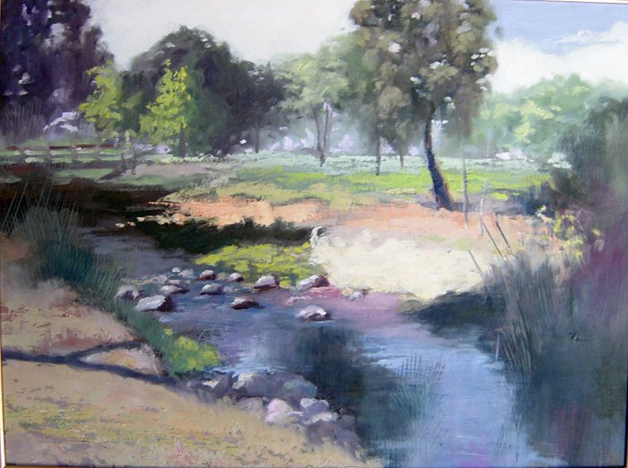 A serene nature scene depicting a winding creek surrounded by lush greenery and scattered rocks, inviting tranquility and a sense of peace.