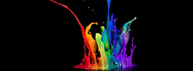 Vibrant splashes of colorful paint erupt dynamically against a black background, creating an artistic display of fluid motion and vivid hues.