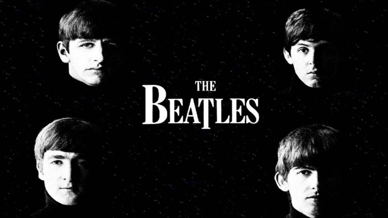 A black and white image featuring the four members of The Beatles, highlighting their iconic looks against a dark background. The band's name is prominently displayed.