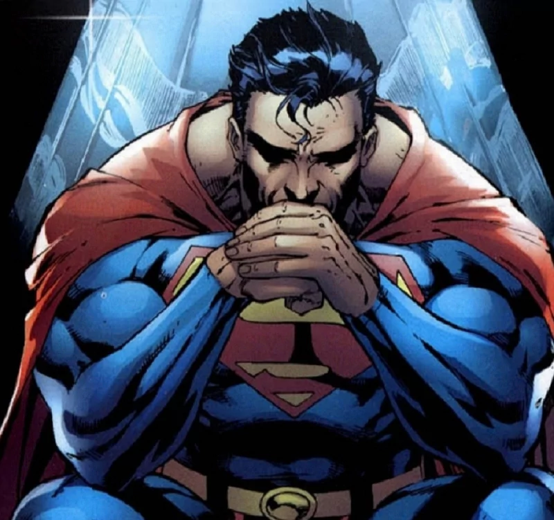 Superman, a DC Comics character, is depicted in deep thought, seated and clasping his hands together, with his iconic cape and blue costume highlighted against a dramatic background.
