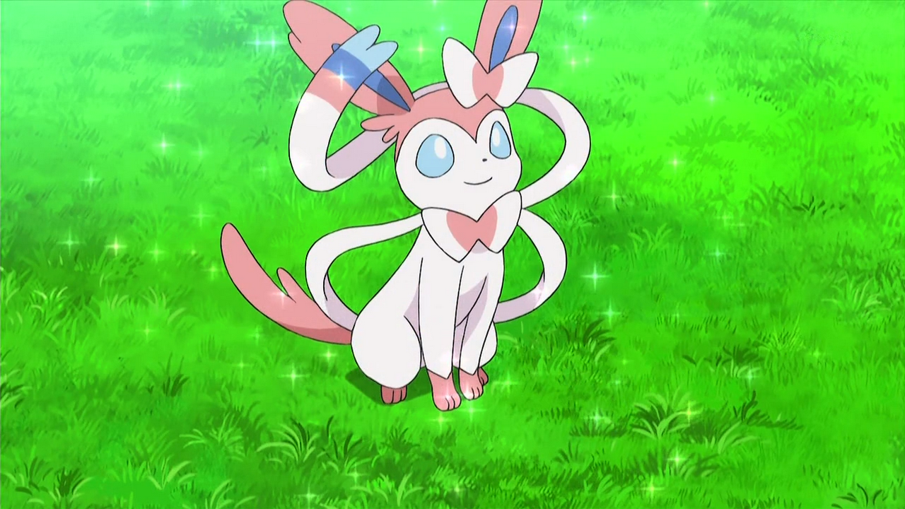 Sylveon, a Fairy-type Pokémon from the anime series, is depicted sitting on lush green grass, surrounded by sparkling lights, exuding charm and playfulness.