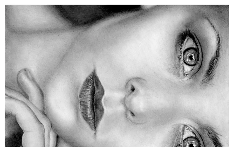 A detailed black and white drawing of a woman's face, capturing expressive eyes and softly shaded features in a painting-like style.