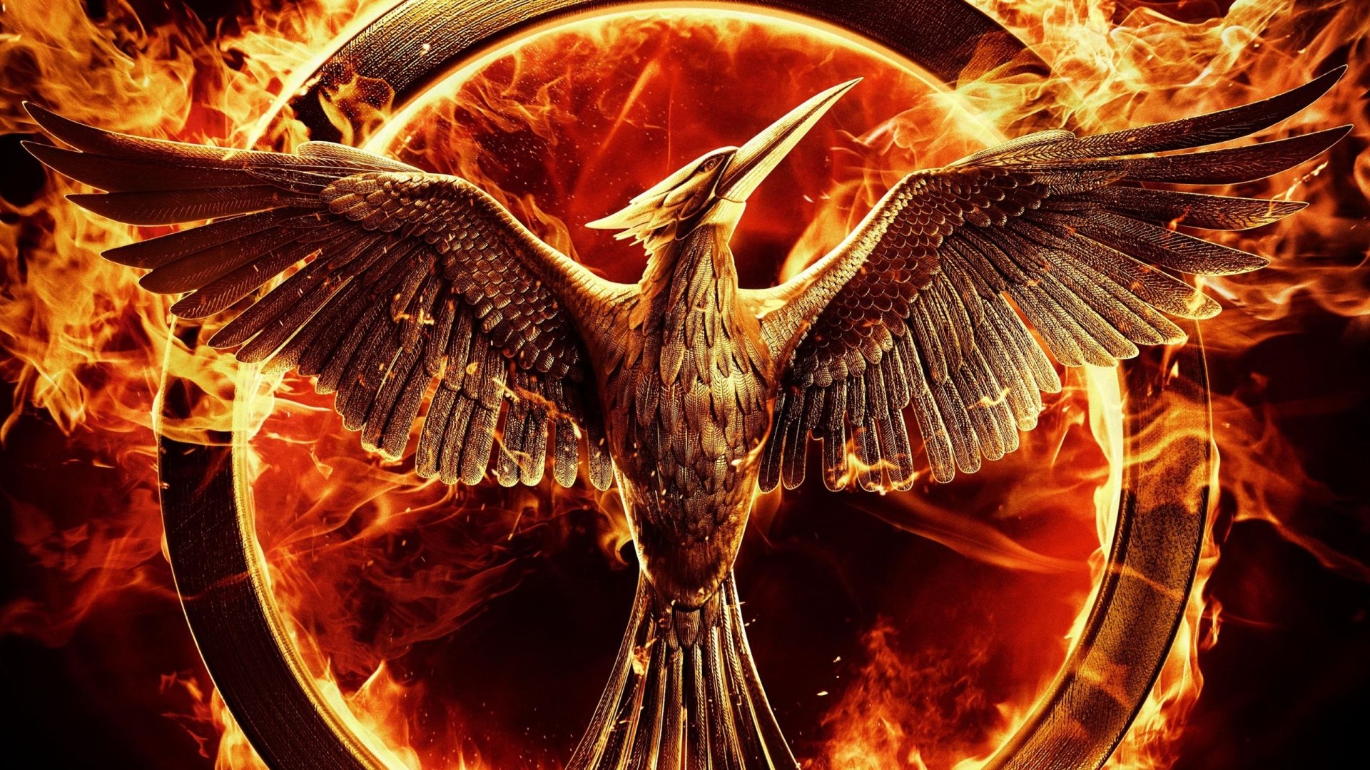 Fiery Mockingjay emblem — a metallic bird with outstretched wings inside a ring of flames, promotional image for the movie The Hunger Games: Mockingjay - Part 1.