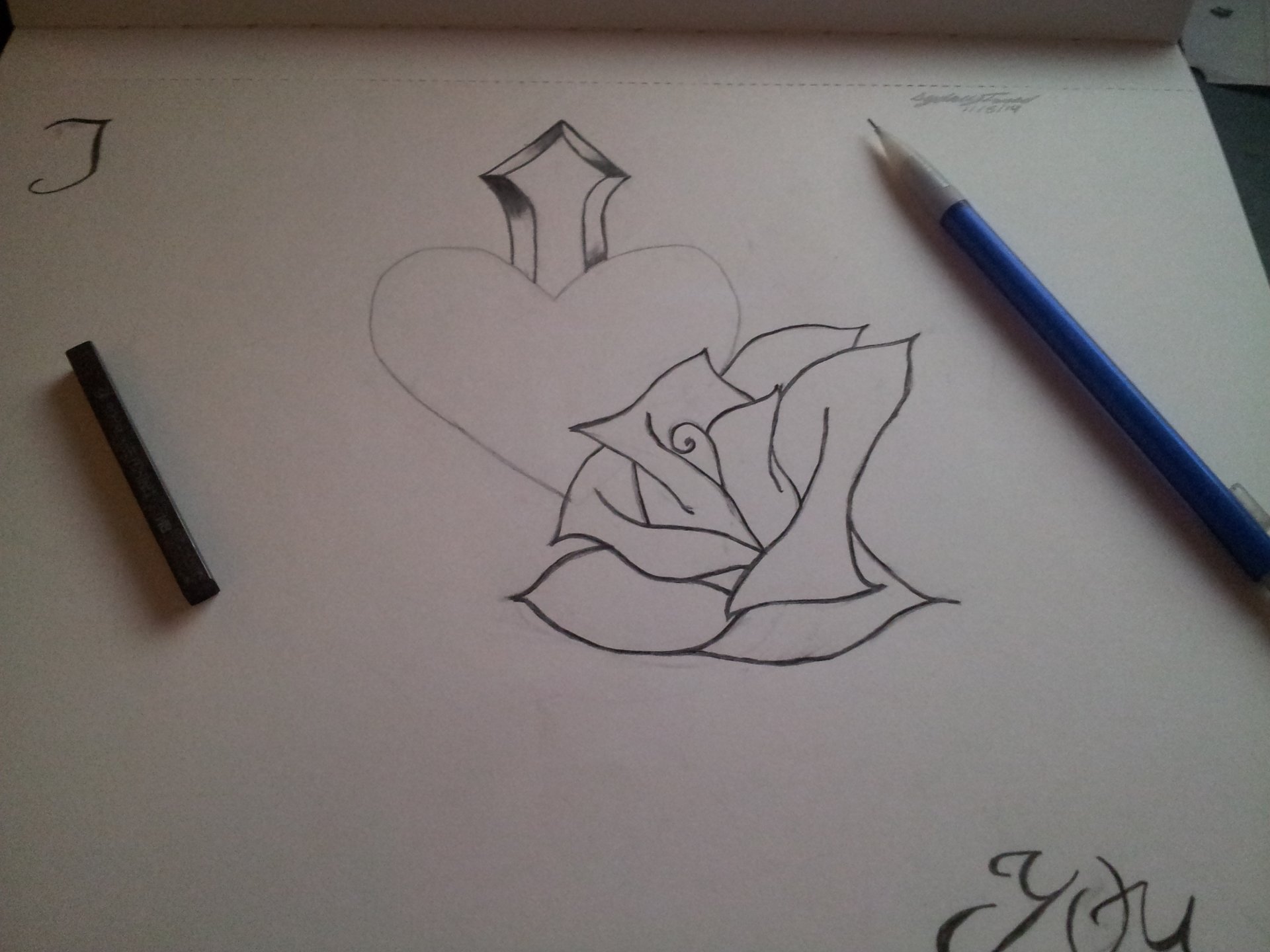 WIP artistic drawing of a heart with a cross on top and a detailed rose overlapping the heart, accompanied by a pencil and a pen on the paper.