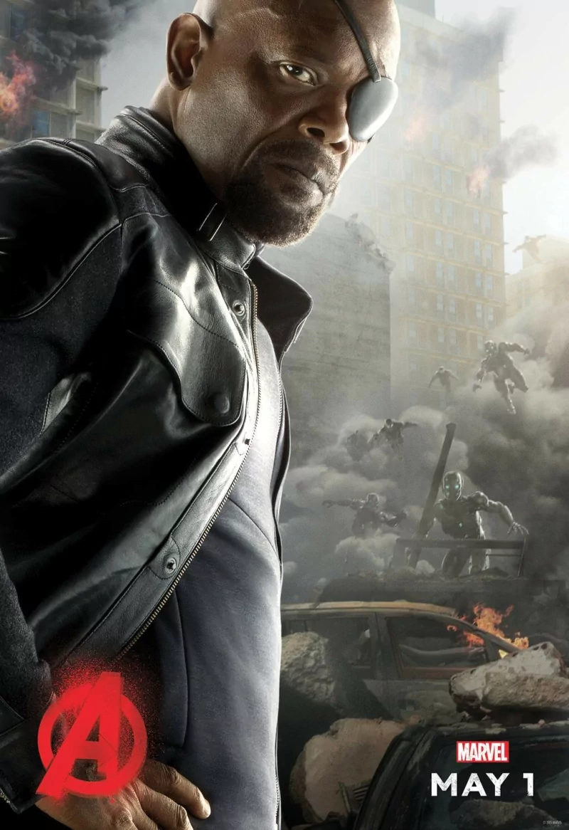 Nick Fury stands confidently in a dramatic scene from Avengers: Age of Ultron, surrounded by chaos and action in a devastated urban landscape.
