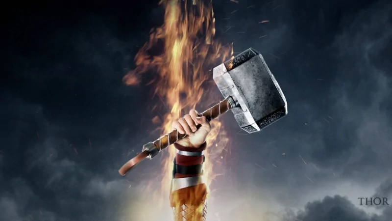 Hand raises Mjolnir through flames against a stormy sky — promotional art for the movie Thor: The Dark World.