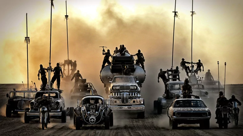 Mad Max: Fury Road convoy of armored war rigs and motorcycles racing across a desert, silhouetted riders atop vehicles, dust and smoke filling the sky.
