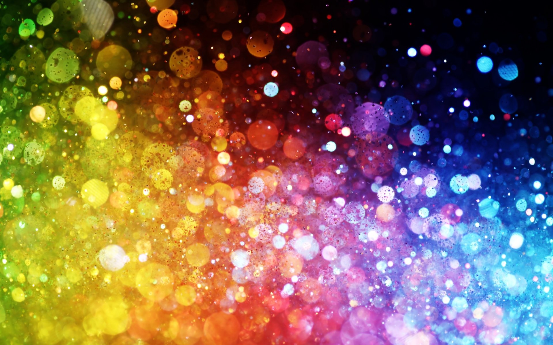 Artistic image featuring a vibrant array of colors blending smoothly from yellow and green to red, purple, and blue, with bright bokeh light effects throughout.