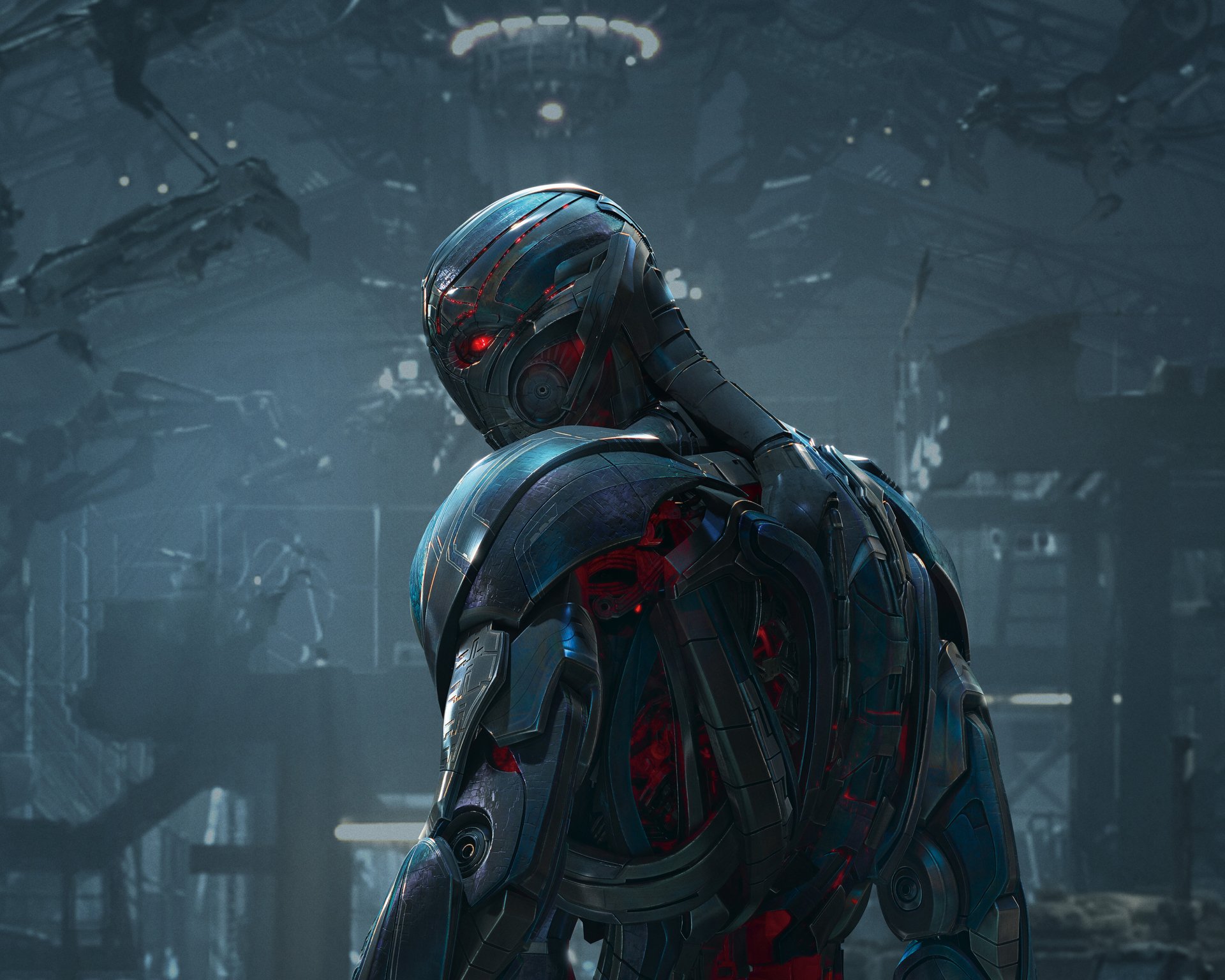 A menacing robot with glowing red eyes stands in a dark, industrial setting, representing Ultron from the movie Avengers: Age of Ultron.