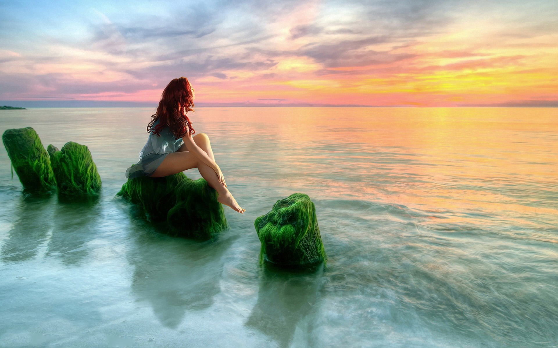 Girl Sitting on Moss-Covered Ocean Rocks