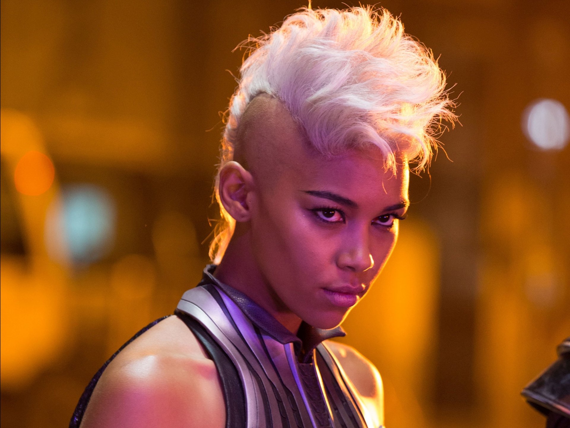 A fierce character portrayal of Storm from Marvel Comics in the movie X-Men: Apocalypse, featuring her striking white mohawk and an intense expression.