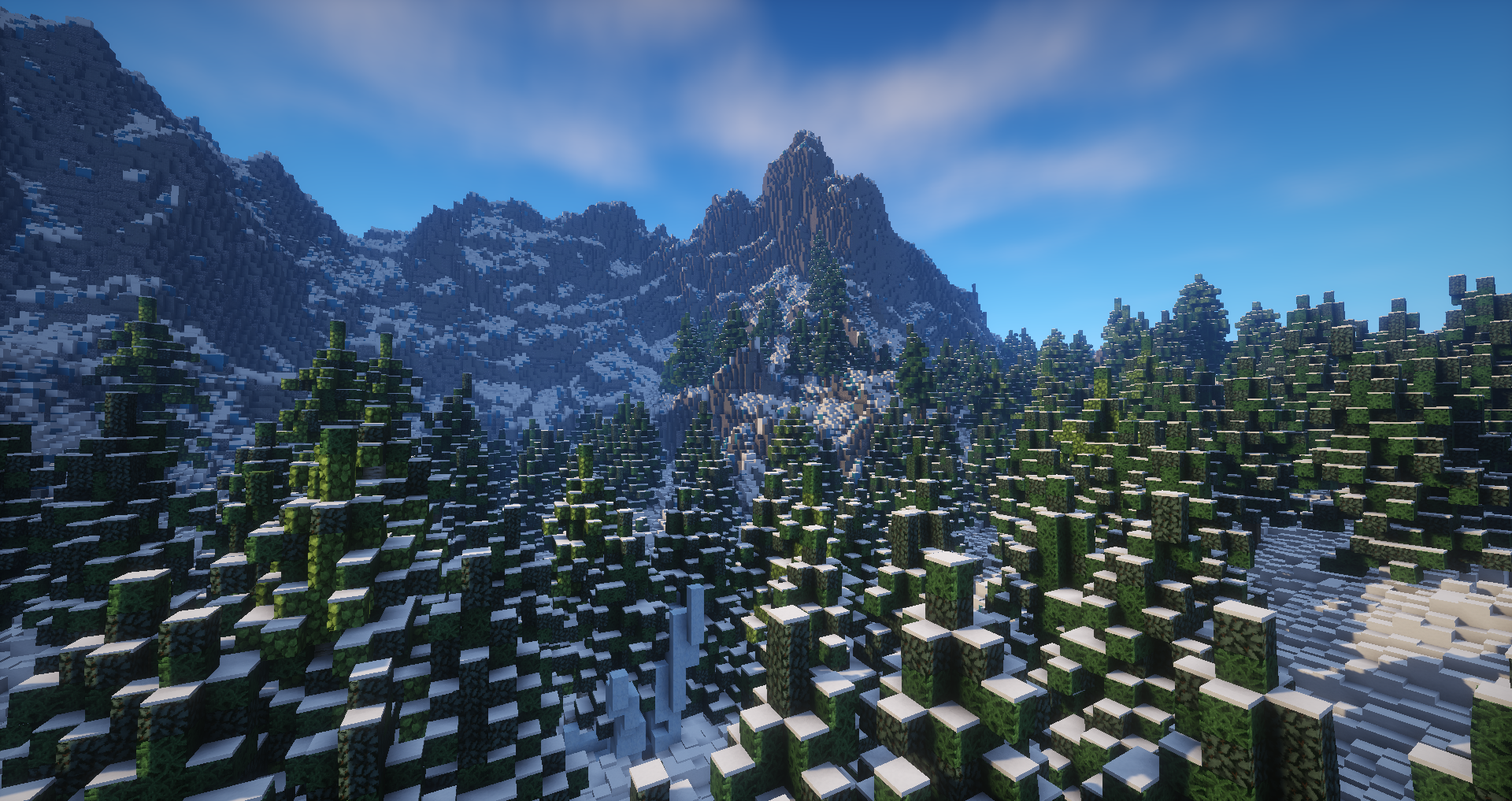 Minecraft video game Snowy Mountain landscape: snow-dusted pine forest beneath towering, pixelated mountain peaks under a clear blue sky.
