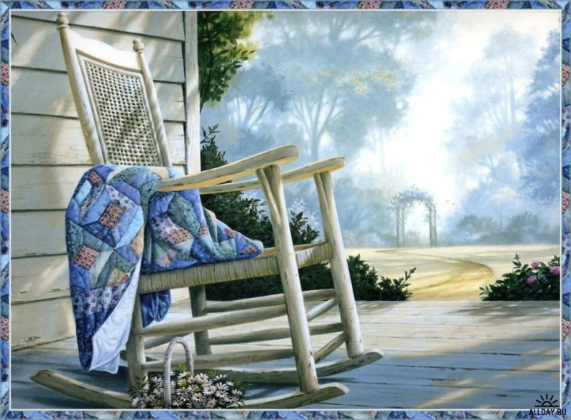 A rocking chair adorned with a colorful quilt sits on a serene porch, surrounded by greenery and a misty landscape, highlighting the charm of man-made furniture.